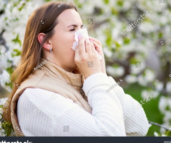 Stock Photo Sneezing Woman With A Nose Wiper Among The Flowering Trees In The Park 2294139625 1
