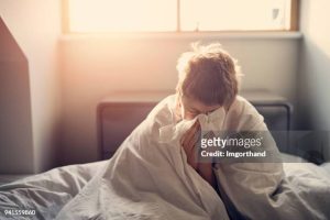 Portrait Of Sick Little Boy Aged 8 Lying In Bed. Nikon D850